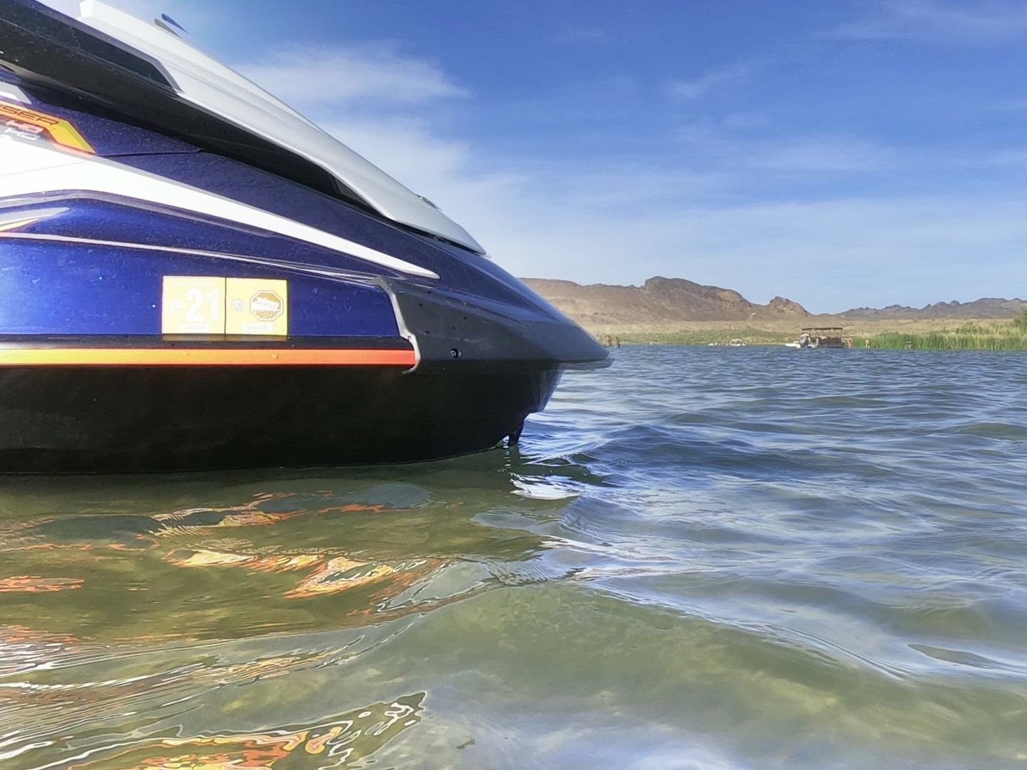Bow of a blue jet ski in shallow water